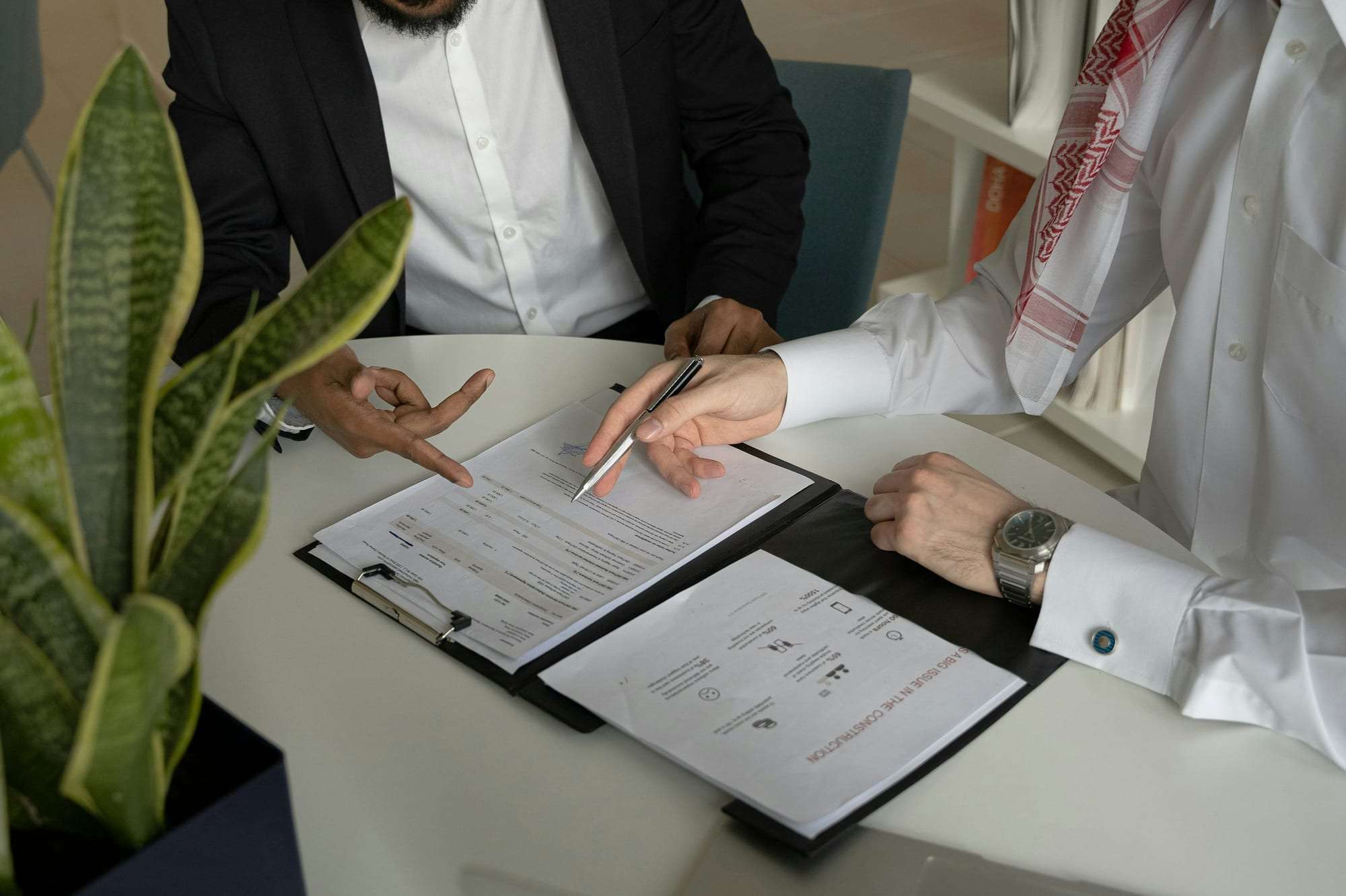 Two people reviewing printed documents together at a table