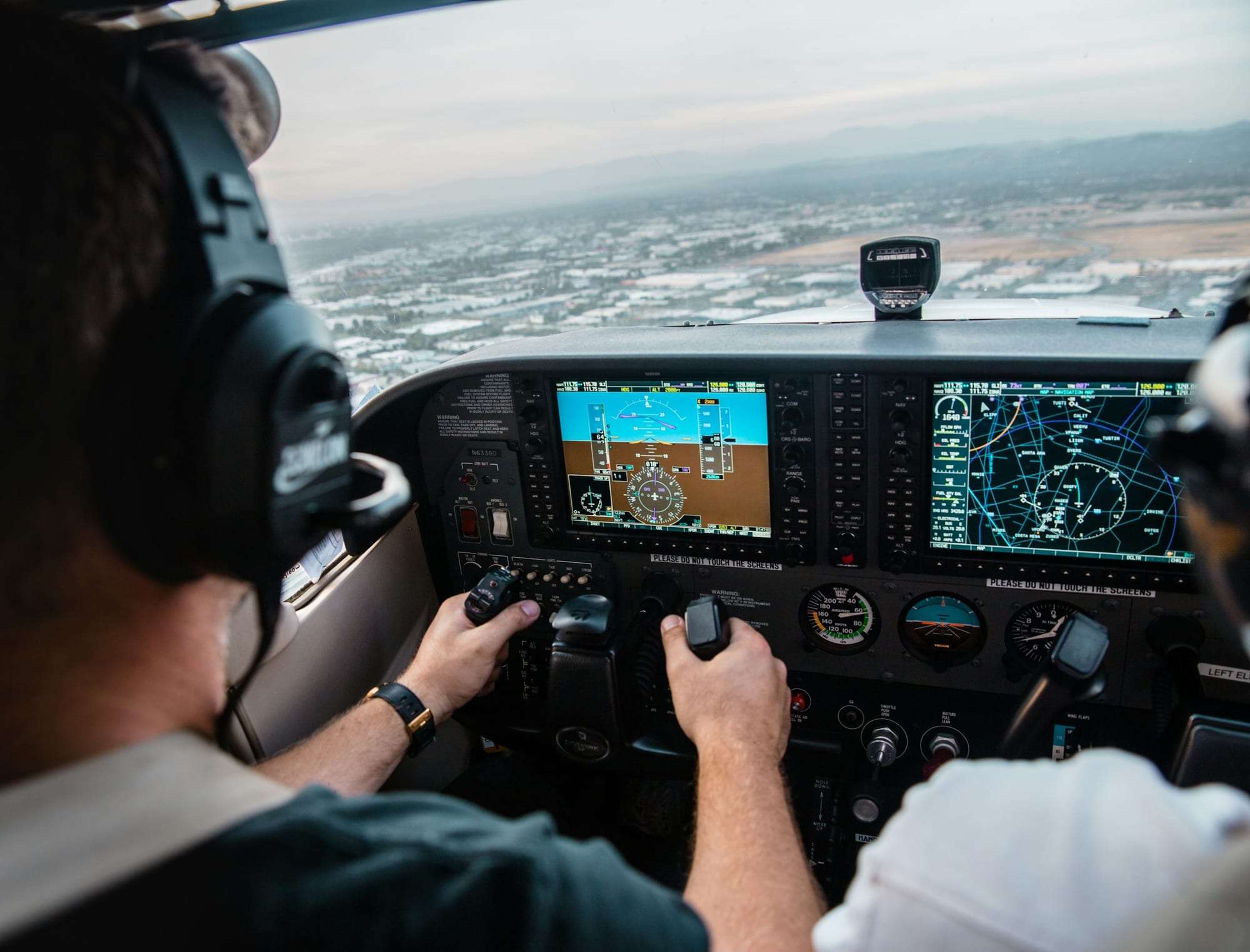 A pilot's hands on the controls in a light aircraft cockpit
